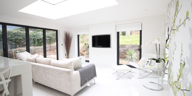 Internal shot of new rear extension created by OPB in Heswall, Wirral.  Picture show floor to ceiling aluminium windows and bi-fold doors complete with flat modern roof windows to create a light filled modern living area.